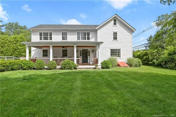 a front view of a house with a yard and trees