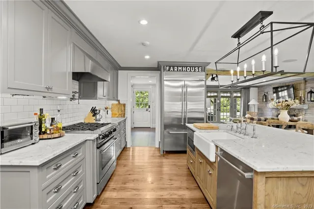 a large kitchen with stainless steel appliances granite countertop a lot of counter space and wooden floor