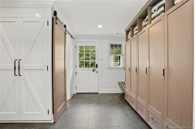 a view of a hallway with wooden floor and closet
