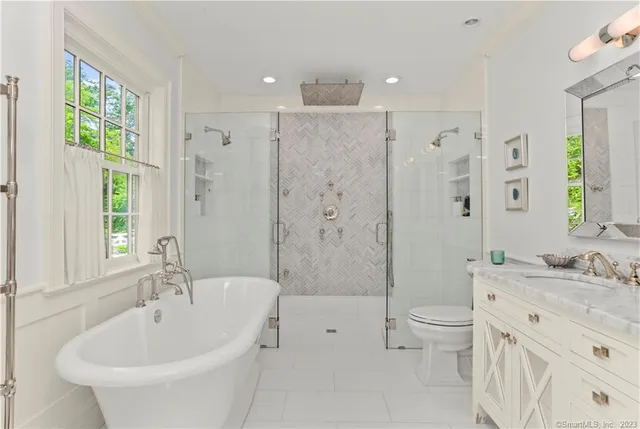 a bathroom with a bathtub shower sink mirror and toilet