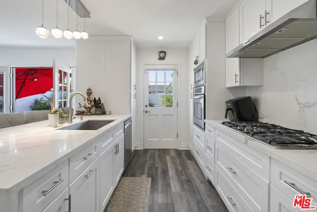 a kitchen with granite countertop a sink stove and cabinets