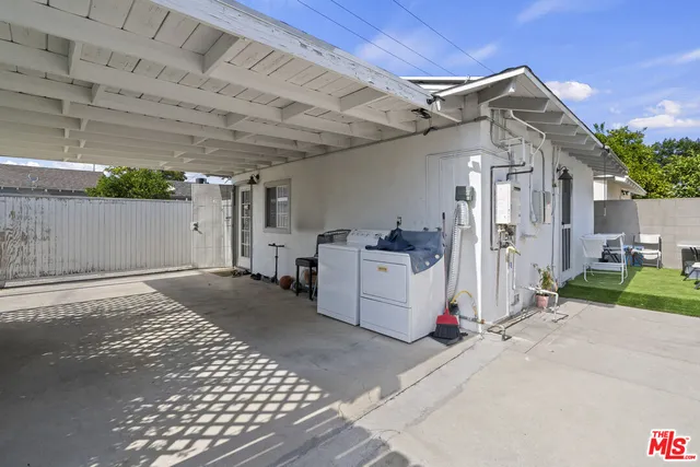 a view of a white house with a sink and yard