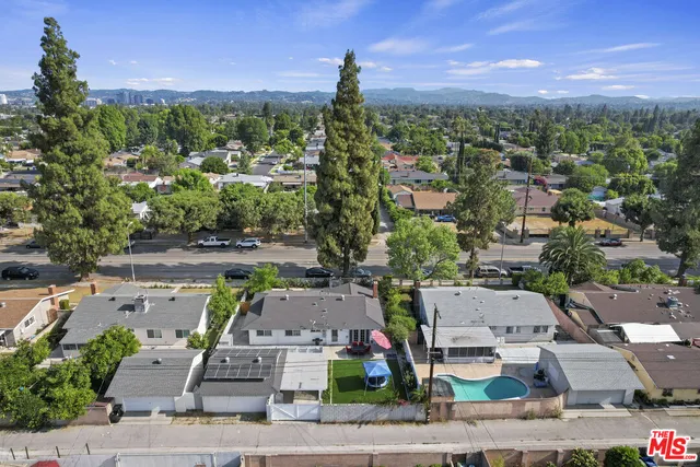 an aerial view of residential houses with outdoor space and street view