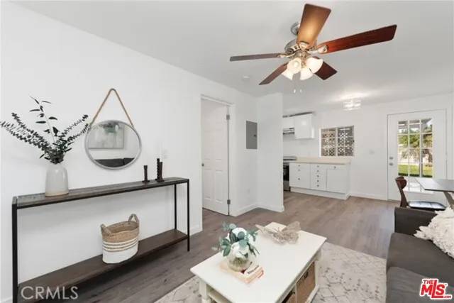 a kitchen with wooden floors and white cabinets