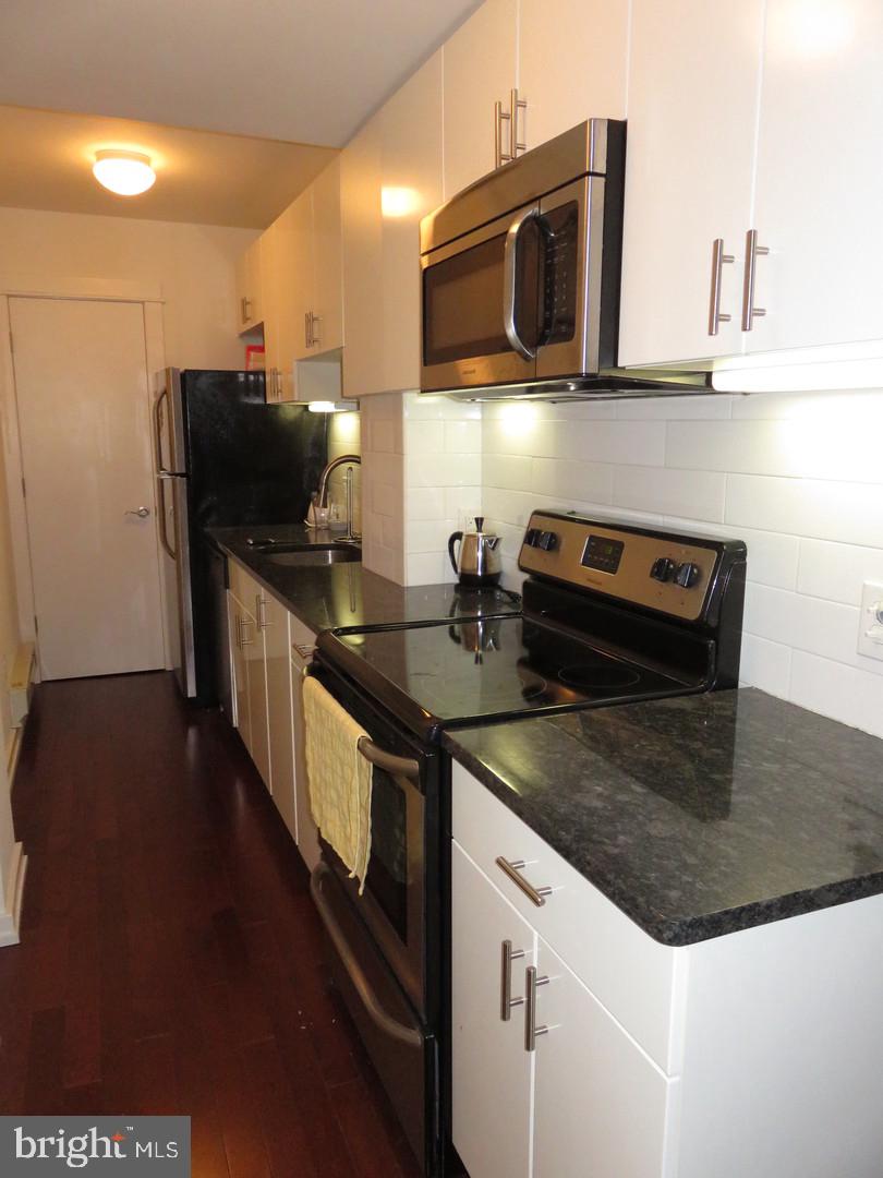 1300 Spruce Street, Unit 3A Philadelphia, PA 19107 - Photo 2 of 9 a kitchen with stainless steel appliances granite countertop a stove a microwave and a refrigerator