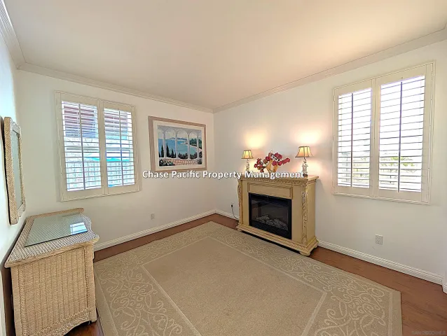 an empty room with windows and fireplace