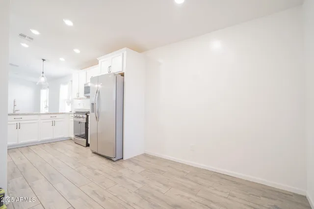 a view of a kitchen with a refrigerator and a sink