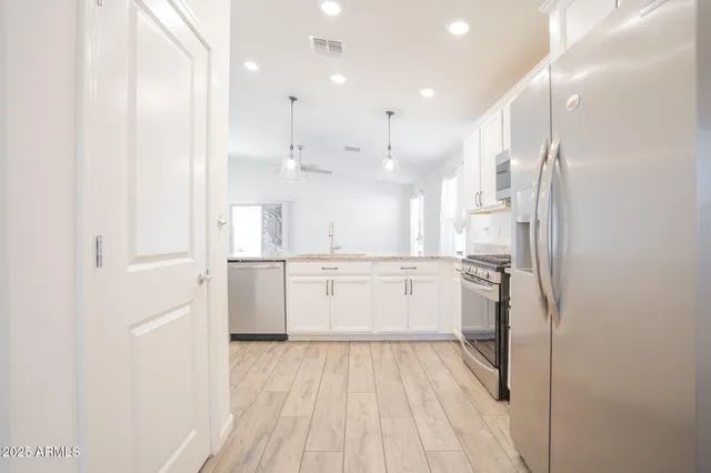 a kitchen with a refrigerator sink and cabinets