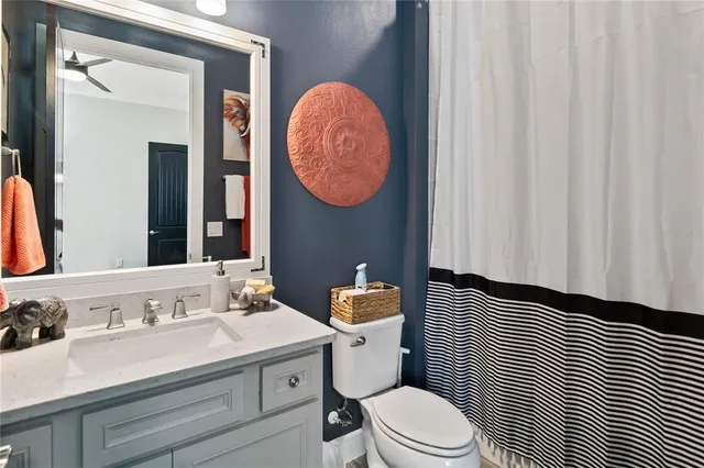 a bathroom with a sink vanity mirror and toilet