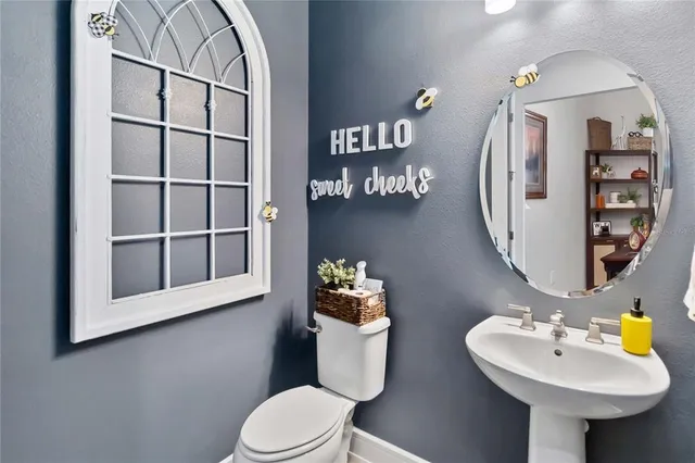 a bathroom with a sink mirror and toilet