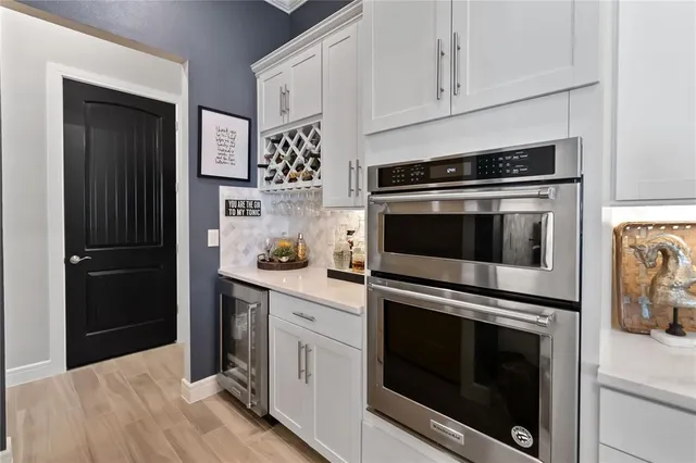 a kitchen with cabinets stainless steel appliances and wooden floor