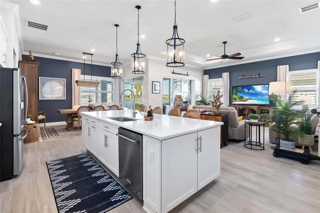 a kitchen with a sink stainless steel appliances and living room view