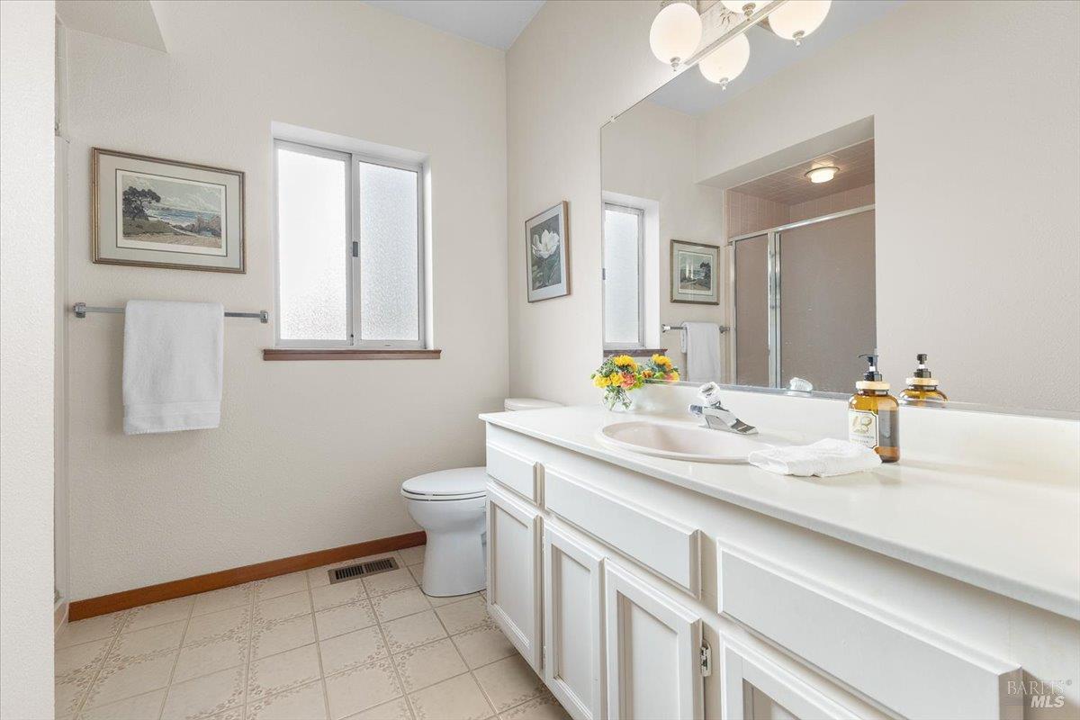 910-920 Lytton Springs Road Healdsburg, CA 95448 - Photo 33 of 59 a bathroom with a granite countertop sink mirror vanity and toilet