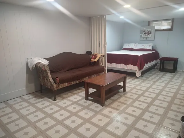 a spacious bedroom with a bed a couch and a dresser in it