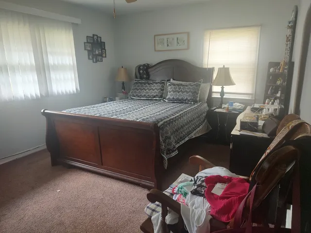 a bedroom with a bed and a lamp on dresser