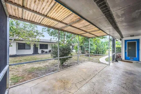 a view of a patio with table and chairs under an umbrella with a big yard