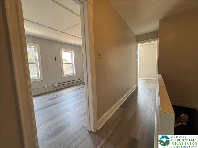a view of a hallway with wooden floor and staircase