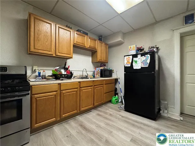 a kitchen with stainless steel appliances granite countertop a refrigerator stove and sink
