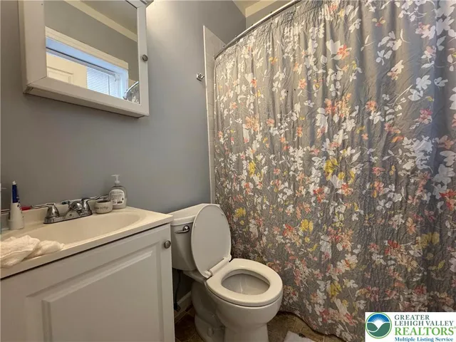 a bathroom with a granite countertop toilet and a sink
