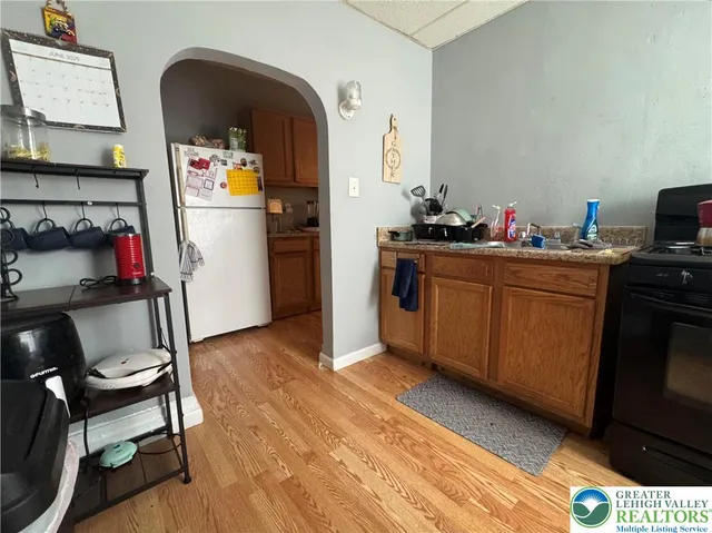 a kitchen with stainless steel appliances kitchen island granite countertop a refrigerator and a stove top oven