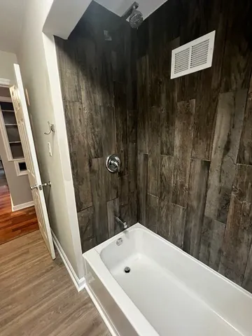 a view of a hallway with wooden floor and chair
