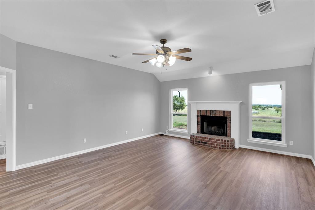 154 Richard Road Waxahachie, TX 75167 - Photo 20 of 38 an empty room with fireplace wooden floor and windows