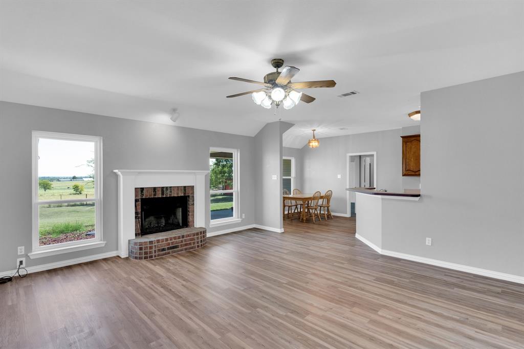 154 Richard Road Waxahachie, TX 75167 - Photo 21 of 38 an empty room with fireplace wooden floor and windows