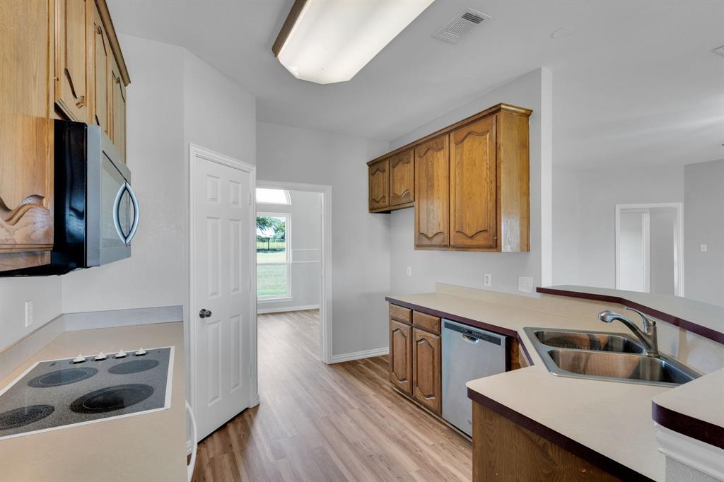 154 Richard Road Waxahachie, TX 75167 - Photo 26 of 38 a kitchen with a sink and a refrigerator