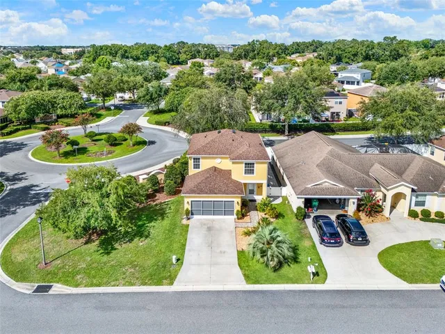 an aerial view of residential houses with outdoor space and street view