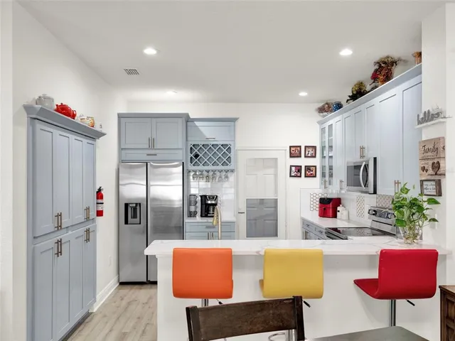 a kitchen with stainless steel appliances granite countertop a refrigerator and a dining table