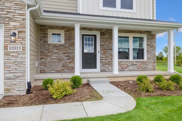 front view of a brick house with a yard