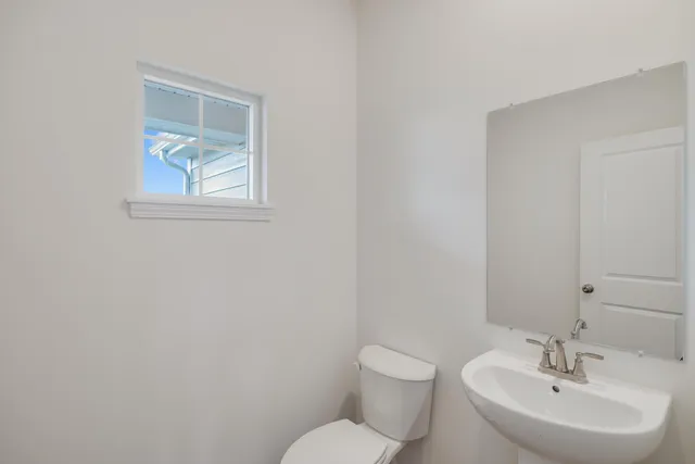 a bathroom with a toilet a sink and mirror