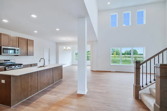 a large kitchen with stainless steel appliances granite countertop a large counter top a stove and a sink