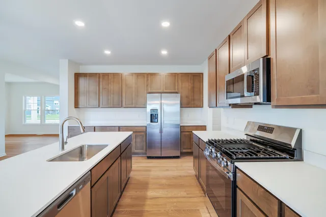 a kitchen with stainless steel appliances granite countertop a sink stove and refrigerator