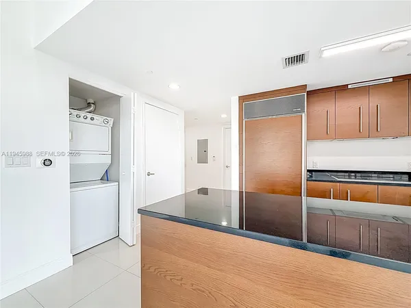 a large kitchen with stainless steel appliances granite countertop a refrigerator and a sink