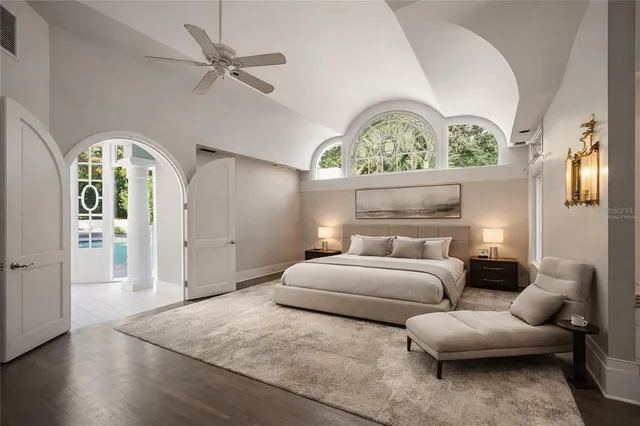 a spacious bedroom with a bed and a chandelier