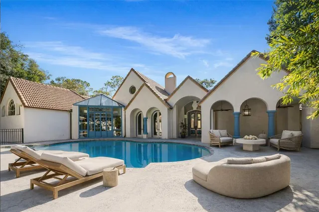 a view of a white house with a big yard and potted plants