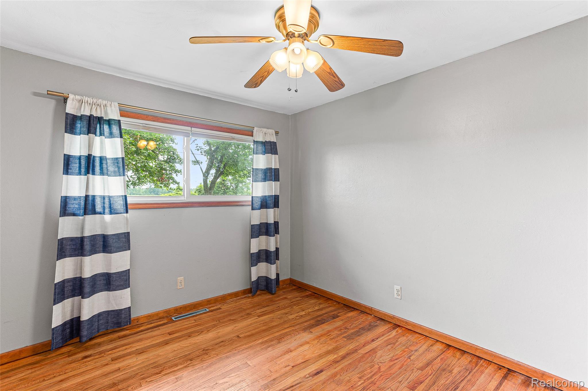 9561 Exeter Road Carleton, MI 48117 - Photo 24 of 46 Hardwood flooring, painted walls, window with wood trim, and a ceiling fan with integrated lighting