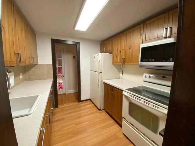 a kitchen with granite countertop a refrigerator and a sink