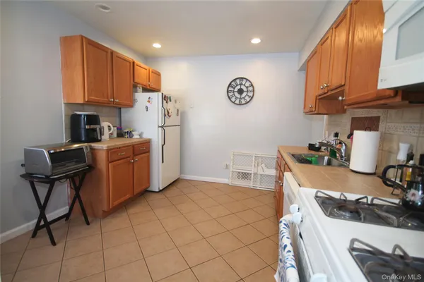 a kitchen with stainless steel appliances granite countertop a sink a stove a refrigerator cabinets and chairs
