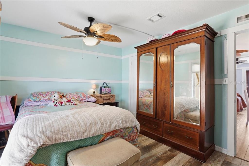 8931 Blind Pass Road, Unit 360 St. Pete Beach, FL 33706 - Photo 11 of 20 a bedroom with a bed and a chandelier