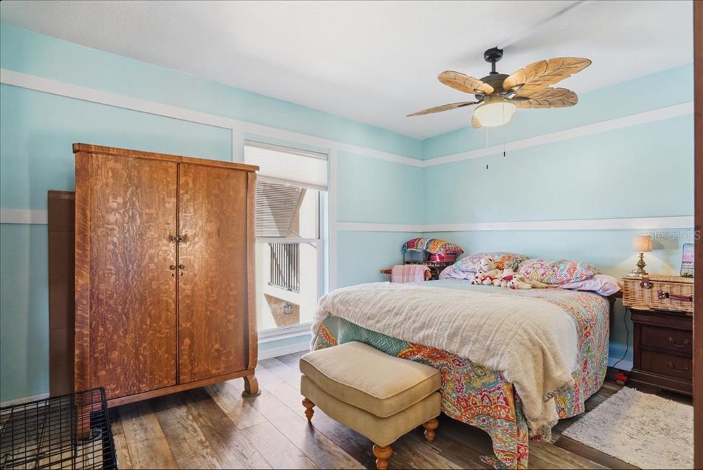 8931 Blind Pass Road, Unit 360 St. Pete Beach, FL 33706 - Photo 12 of 20 a bedroom with a bed and a chandelier