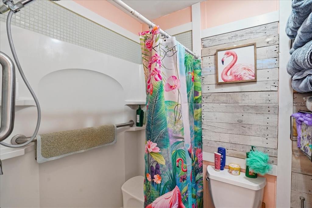 8931 Blind Pass Road, Unit 360 St. Pete Beach, FL 33706 - Photo 14 of 20 a bathroom with a sink a mirror and painting on the wall