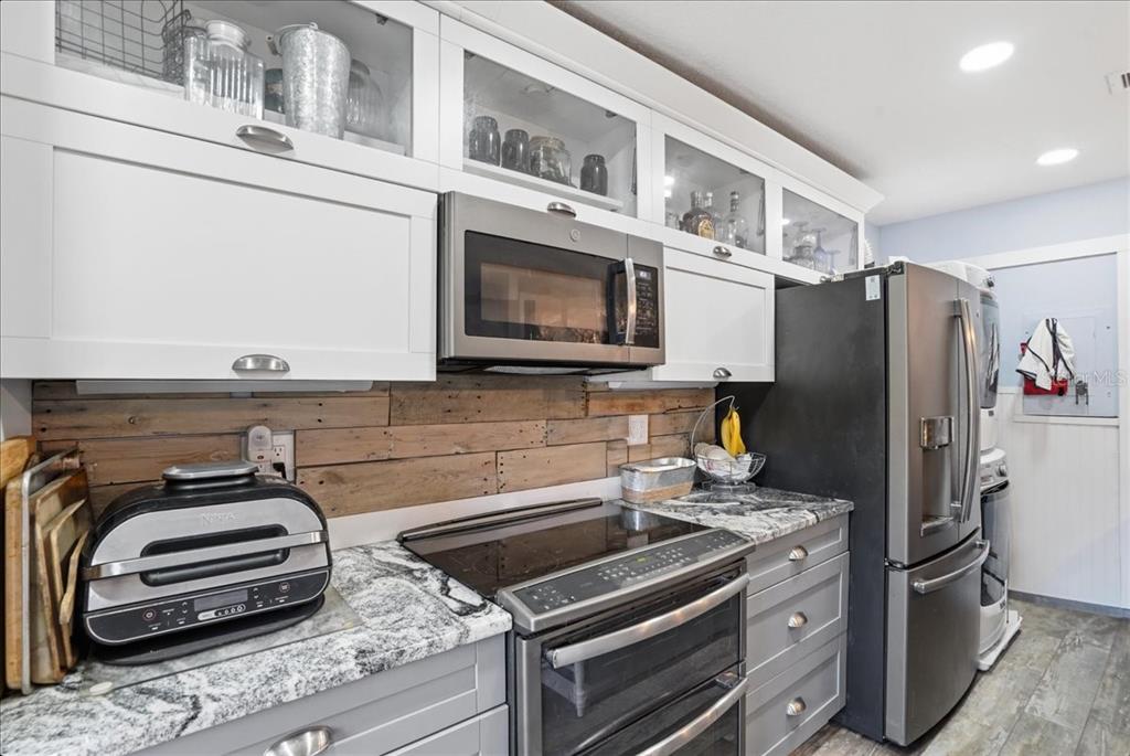8931 Blind Pass Road, Unit 360 St. Pete Beach, FL 33706 - Photo 8 of 20 a kitchen with stainless steel appliances a stove a refrigerator and a microwave