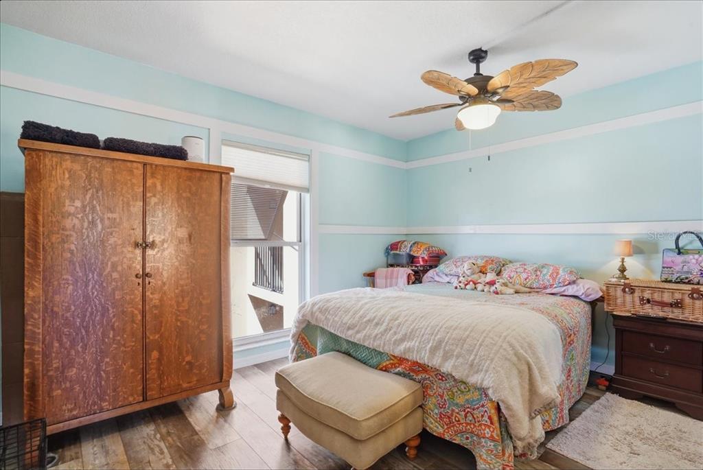 8931 Blind Pass Road, Unit 360 St. Pete Beach, FL 33706 - Photo 9 of 20 a bedroom with a bed and a chandelier