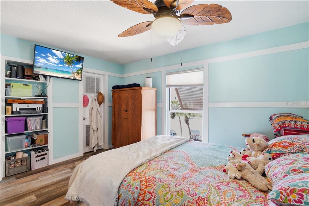 8931 Blind Pass Road, Unit 360 St. Pete Beach, FL 33706 - Photo 10 of 20 a bedroom with a bed and a chandelier