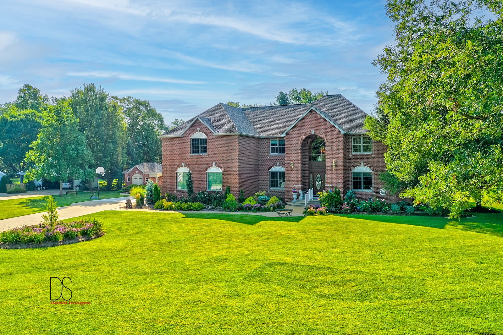 a view of a house with a big yard and large trees