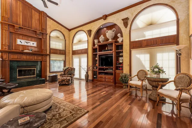 a living room with furniture a fireplace and floor to ceiling windows