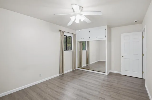 an empty room with a window and a fan