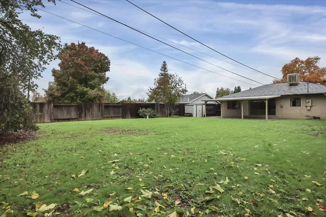 a view of an house with backyard and porch